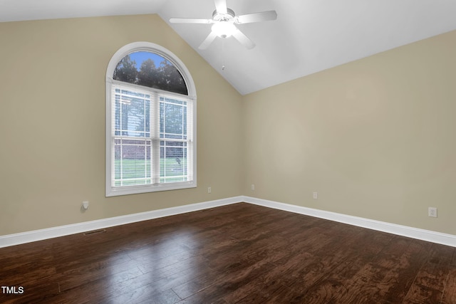 spare room featuring dark wood-type flooring, baseboards, lofted ceiling, and ceiling fan