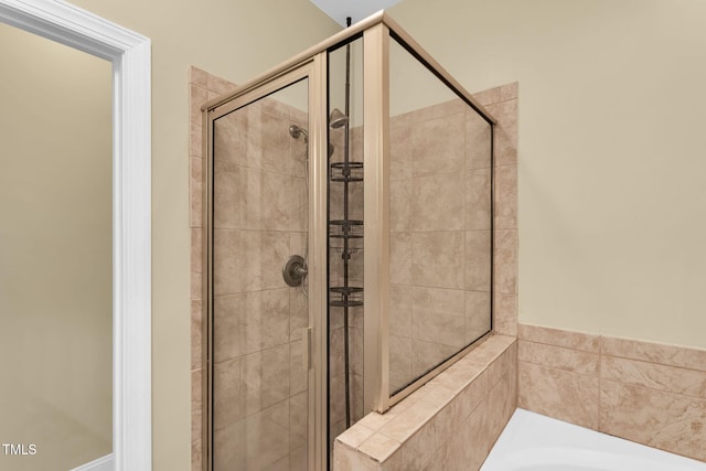 full bathroom featuring a garden tub and a shower stall