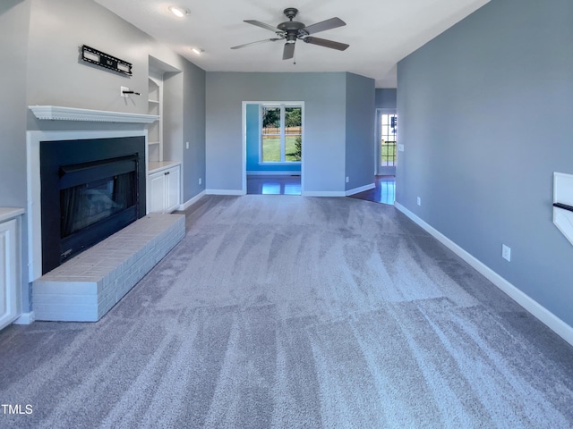 357 Riverwood Dr, Clayton, NC 27527 - unfurnished living room featuring carpet flooring, a brick fireplace, built in features, baseboards, and ceiling fan