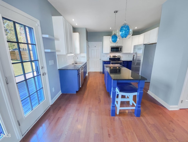 357 Riverwood Dr, Clayton, NC 27527 - kitchen with blue cabinets, a center island, dark wood finished floors, a sink, and appliances with stainless steel finishes