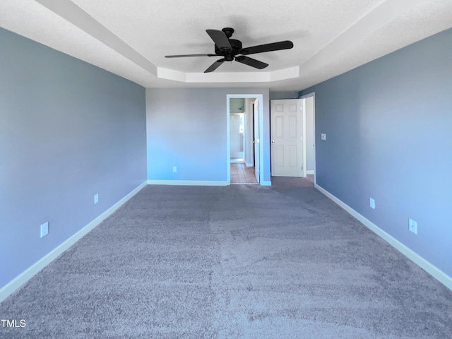 357 Riverwood Dr, Clayton, NC 27527 - unfurnished bedroom with a tray ceiling, baseboards, carpet, and a textured ceiling