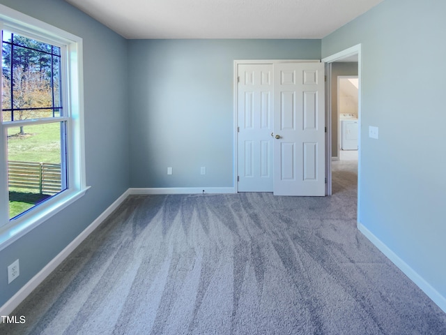 357 Riverwood Dr, Clayton, NC 27527 - unfurnished bedroom with baseboards, carpet floors, a closet, and washer / dryer