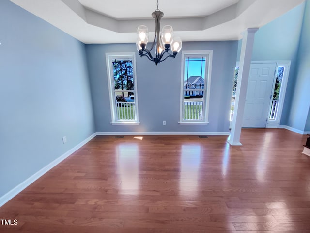 357 Riverwood Dr, Clayton, NC 27527 - unfurnished dining area featuring a tray ceiling, baseboards, dark wood-style flooring, and a chandelier
