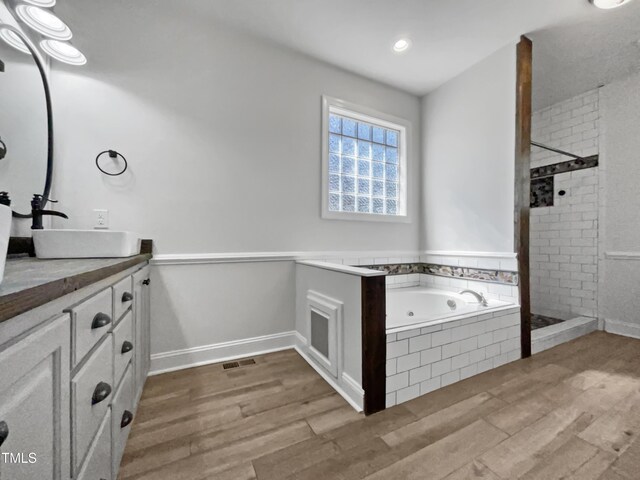 full bath featuring a sink, wood finished floors, and a stall shower