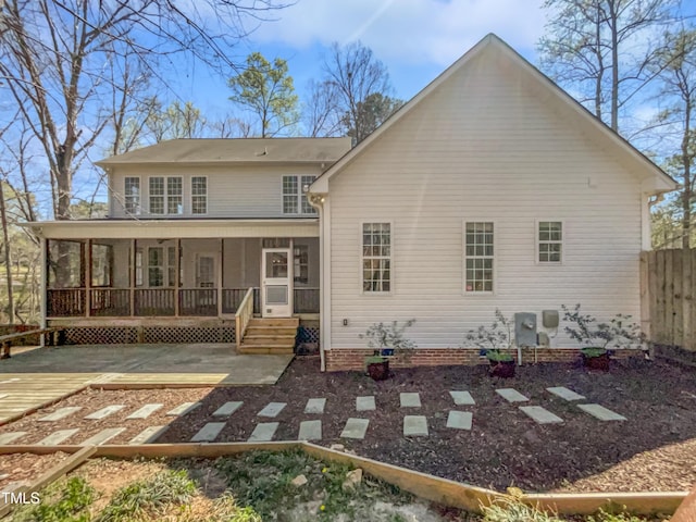 back of property featuring fence, a sunroom, and a patio