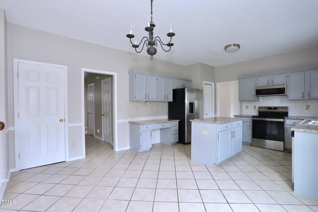 3313 Sparrowhawk Dr, High Point, NC 27265 - kitchen with tasteful backsplash, a center island, a notable chandelier, appliances with stainless steel finishes, and light tile patterned flooring