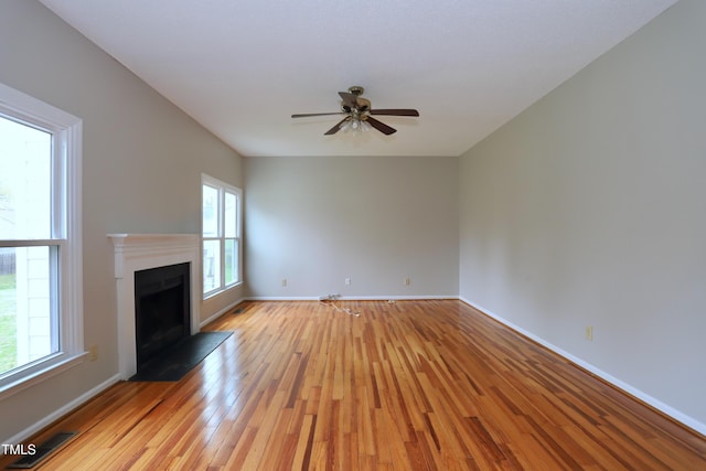 3313 Sparrowhawk Dr, High Point, NC 27265 - unfurnished living room featuring baseboards, a fireplace with flush hearth, light wood-style floors, visible vents, and ceiling fan