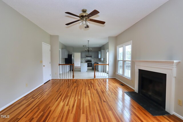 3313 Sparrowhawk Dr, High Point, NC 27265 - unfurnished living room with a fireplace with flush hearth, light wood-style flooring, baseboards, and ceiling fan