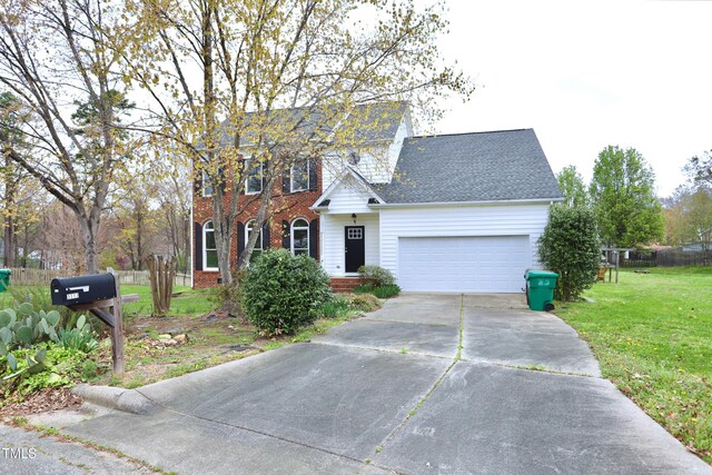 3313 Sparrowhawk Dr, High Point, NC 27265 - colonial house with an attached garage, fence, brick siding, a front lawn, and driveway