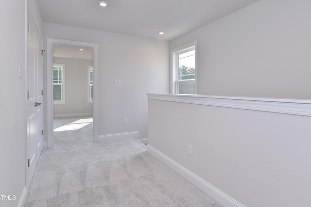 unfurnished room featuring baseboards, plenty of natural light, recessed lighting, and light carpet