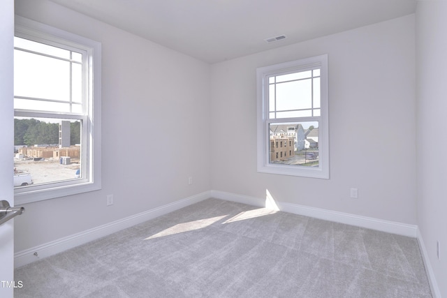 carpeted empty room with baseboards and visible vents