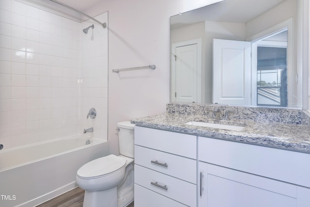 bathroom with bathtub / shower combination, wood finished floors, toilet, and vanity