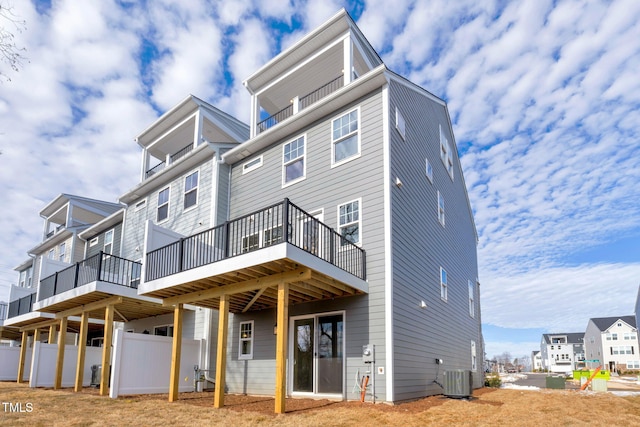 rear view of property with fence, cooling unit, and a wooden deck