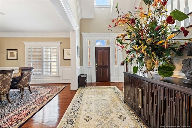 foyer featuring dark wood-style flooring, plenty of natural light, and ornamental molding