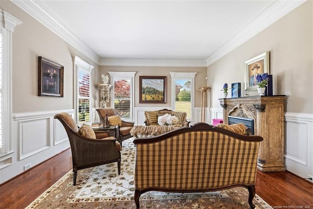 sitting room with a wealth of natural light, wood finished floors, and ornamental molding
