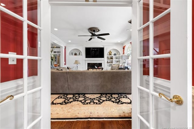 living area with french doors, a ceiling fan, and a fireplace