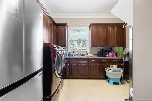 washroom with separate washer and dryer, ornamental molding, cabinet space, and a sink