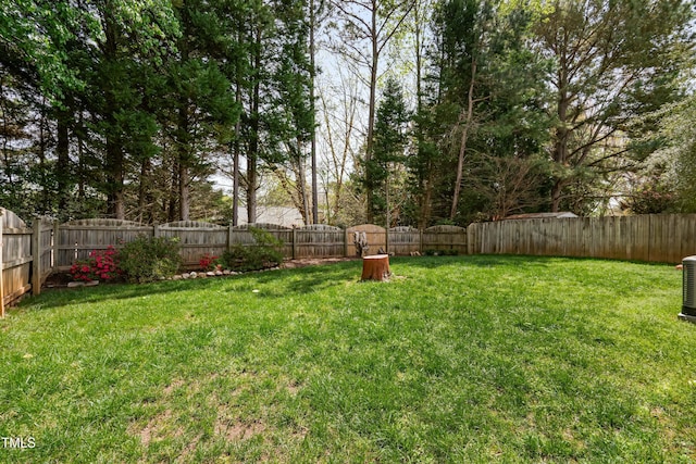 view of yard featuring a fenced backyard and central AC