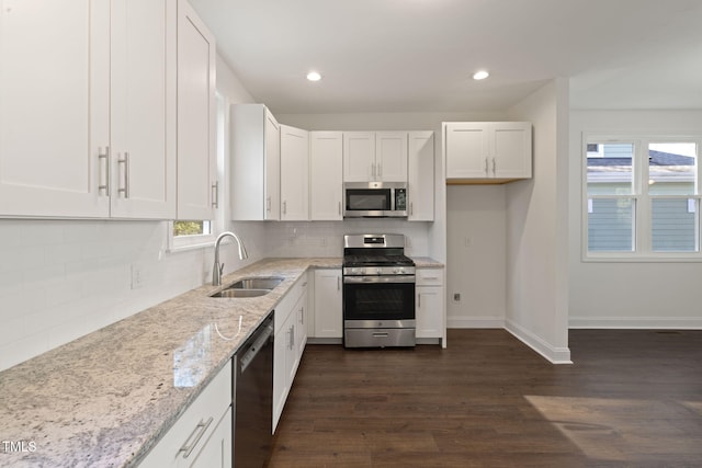 kitchen featuring white cabinetry, light stone countertops, a sink, and stainless steel appliances