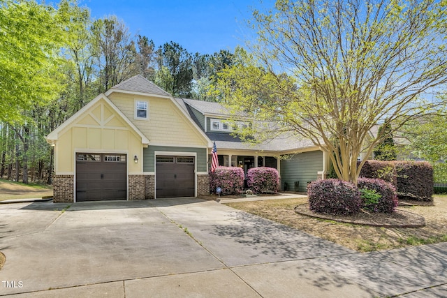 craftsman house featuring a shingled roof, brick siding, and concrete driveway