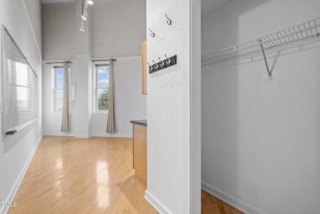 interior space featuring light wood-type flooring and a towering ceiling