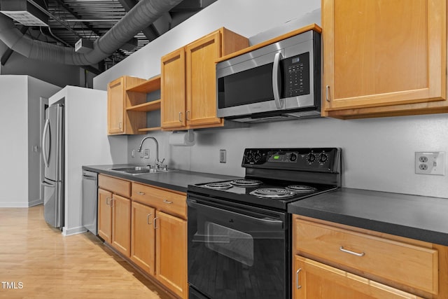 kitchen featuring open shelves, dark countertops, light wood-style floors, stainless steel appliances, and a sink
