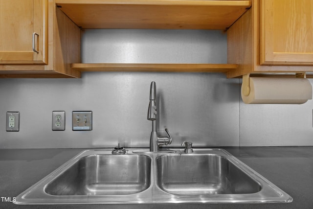 details with a sink, open shelves, and dark countertops