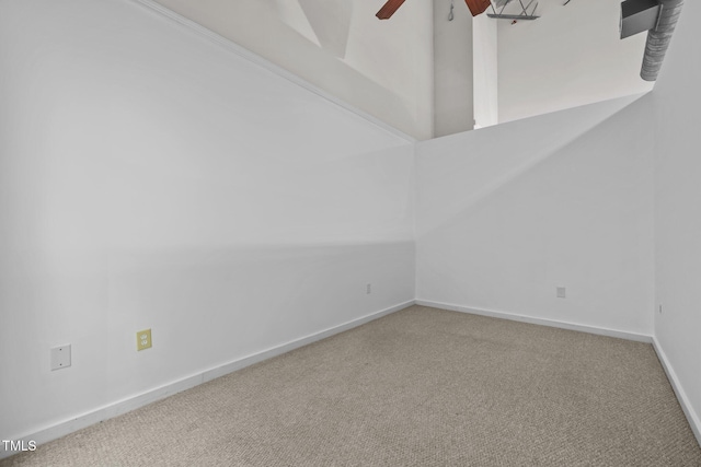 carpeted spare room with baseboards and ceiling fan