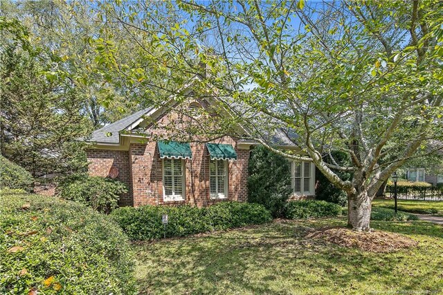 1800 Pugh St, Fayetteville, NC 28305 - view of side of property with a lawn and brick siding