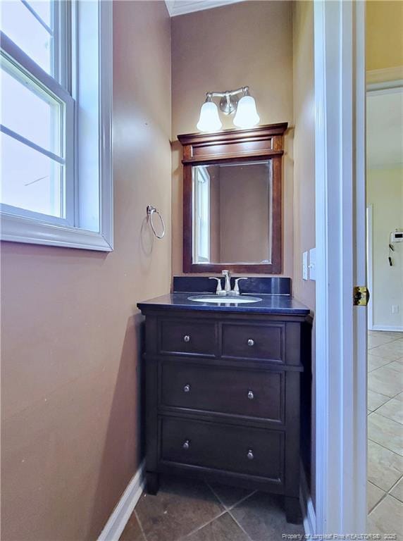 bathroom featuring baseboards, tile patterned floors, and vanity