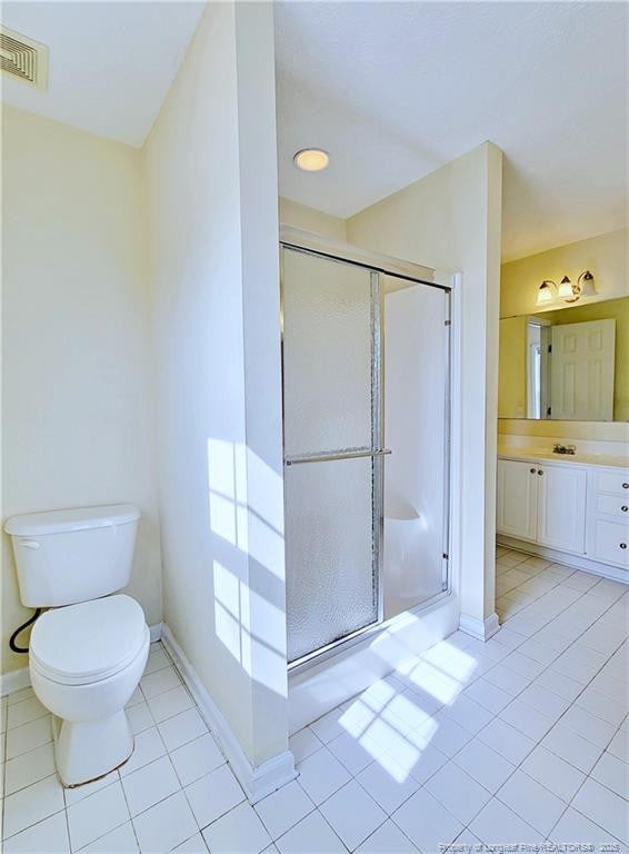 full bathroom with toilet, vanity, a stall shower, and visible vents
