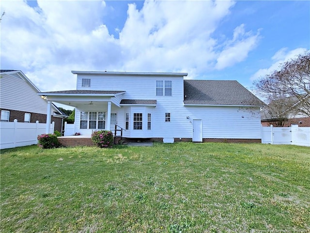 rear view of house with a fenced backyard, roof with shingles, and a yard