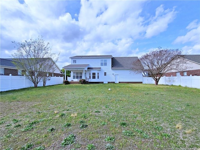 rear view of house with a fenced backyard, roof with shingles, and a lawn