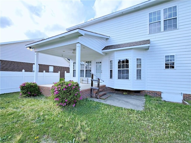 back of property with crawl space, fence, and a yard