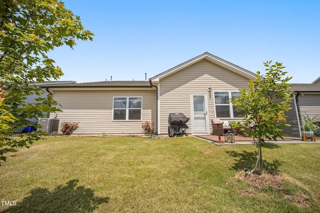 rear view of property featuring a lawn, a patio area, and cooling unit