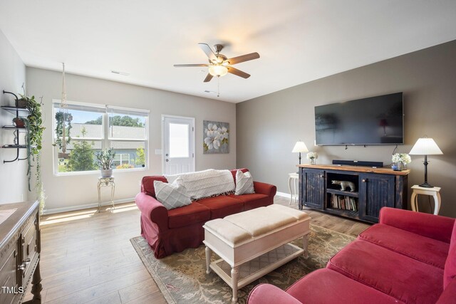 living area with ceiling fan, wood finished floors, and baseboards