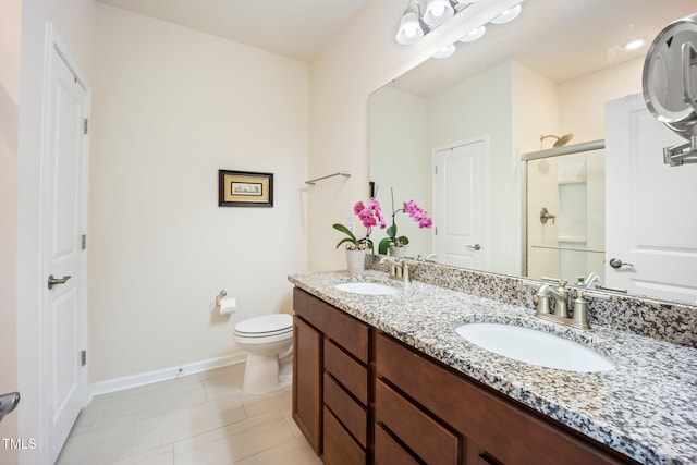 full bath featuring a shower stall, baseboards, toilet, double vanity, and tile patterned flooring