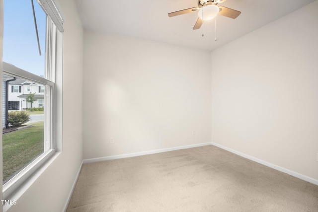 spare room featuring healthy amount of natural light, baseboards, and carpet