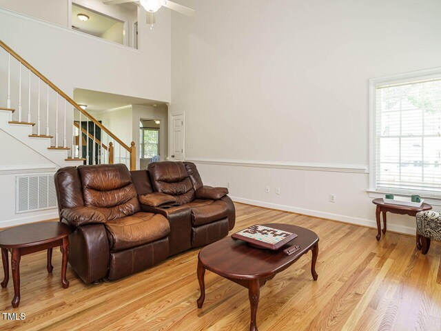 2213 Ravens Creek Ct, Raleigh, NC 27603 - living room featuring visible vents, ceiling fan, light wood-type flooring, and stairs