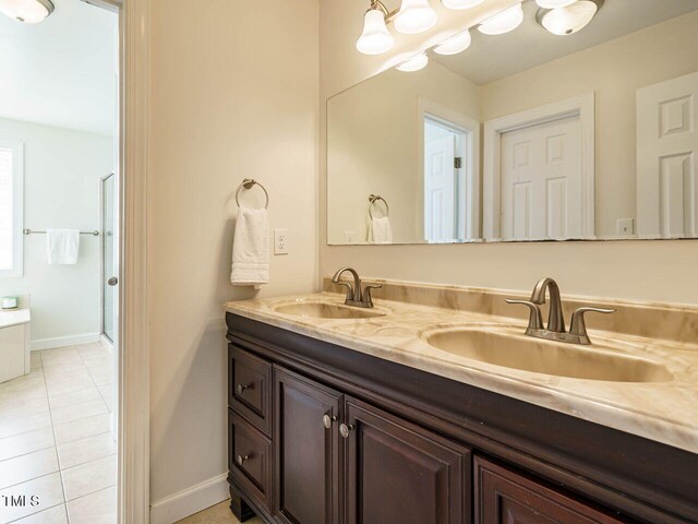 2213 Ravens Creek Ct, Raleigh, NC 27603 - full bathroom with a sink, double vanity, tile patterned flooring, and a stall shower