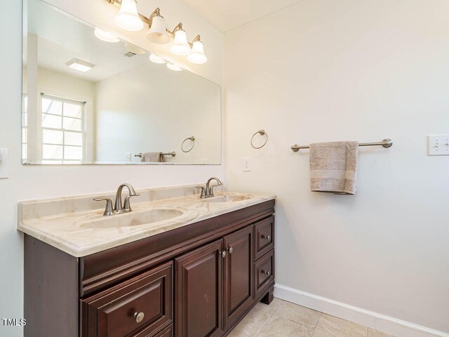 2213 Ravens Creek Ct, Raleigh, NC 27603 - bathroom with a sink, tile patterned floors, baseboards, and double vanity