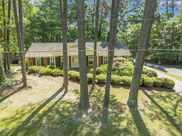 3911 Hope Valley Rd, Durham, NC 27707 - view of front of house featuring brick siding, a front lawn, and view of scattered trees
