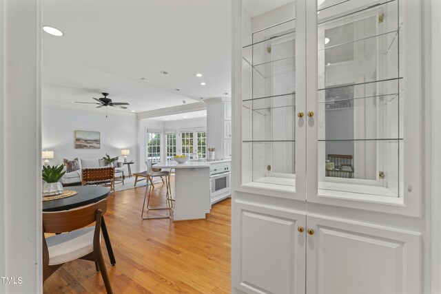 3911 Hope Valley Rd, Durham, NC 27707 - hallway with light wood finished floors, recessed lighting, and ornamental molding