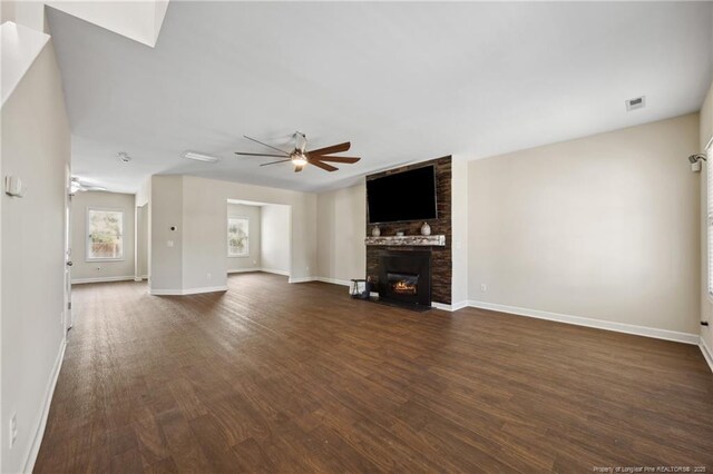 4644 Woodline Dr, Fayetteville, NC 28314 - unfurnished living room with visible vents, ceiling fan, a large fireplace, dark wood-style floors, and baseboards