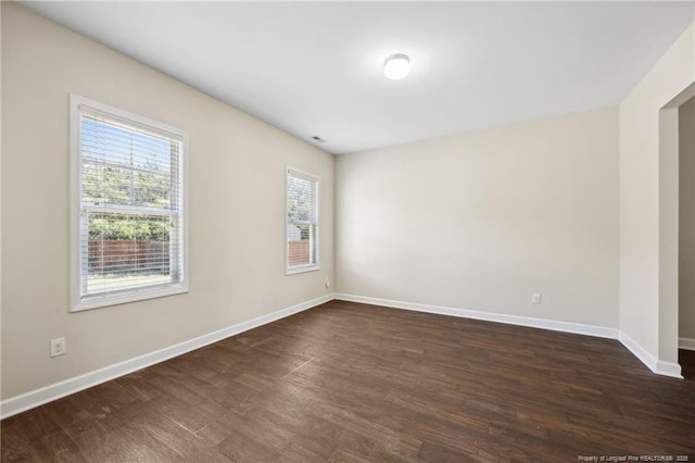 4644 Woodline Dr, Fayetteville, NC 28314 - unfurnished room featuring baseboards, dark wood-style flooring, and a healthy amount of sunlight