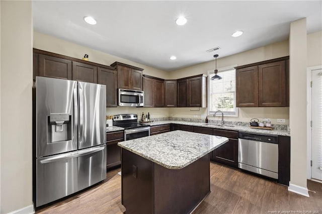 4644 Woodline Dr, Fayetteville, NC 28314 - kitchen featuring a center island, dark brown cabinets, a sink, stainless steel appliances, and visible vents