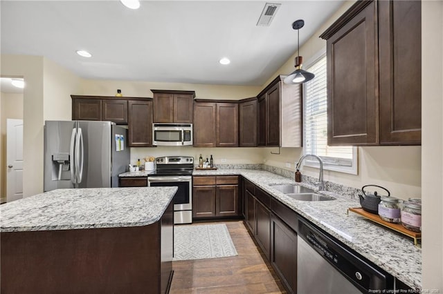 4644 Woodline Dr, Fayetteville, NC 28314 - kitchen featuring a sink, wood finished floors, light stone counters, dark brown cabinets, and appliances with stainless steel finishes