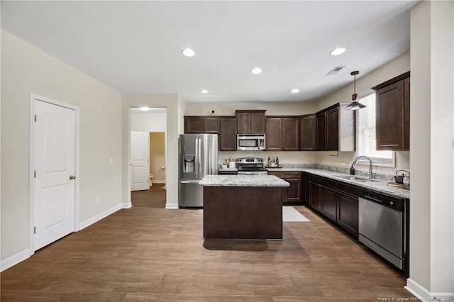 4644 Woodline Dr, Fayetteville, NC 28314 - kitchen with a center island, dark brown cabinets, dark wood finished floors, a sink, and appliances with stainless steel finishes