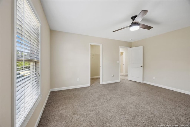 4644 Woodline Dr, Fayetteville, NC 28314 - unfurnished bedroom with a closet, carpet, a spacious closet, a ceiling fan, and baseboards