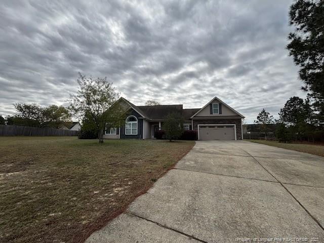 view of front facade featuring driveway, a front yard, and an attached garage